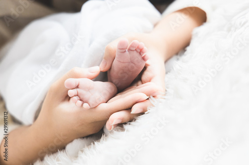 Close up newborn baby 's foot in mother 's hand. Mother 's day concept.
