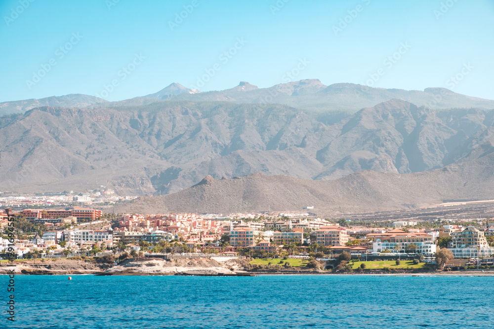 city with hotel buildings at coast with mountain landscape background - ocean view on Tenerife Island