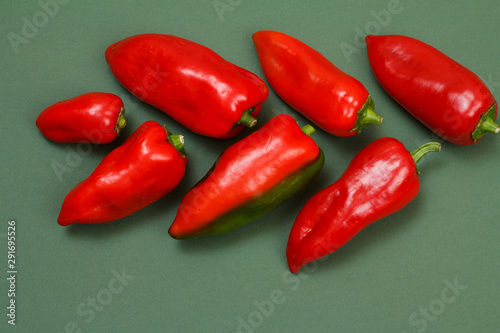 Fresh red bell peppers on green background.