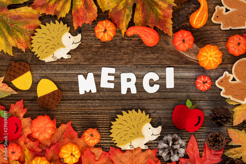 Colorful Autumn Decoration With White Letters Building French Word Merci Means Thank You. Flat Lay With Wooden Background