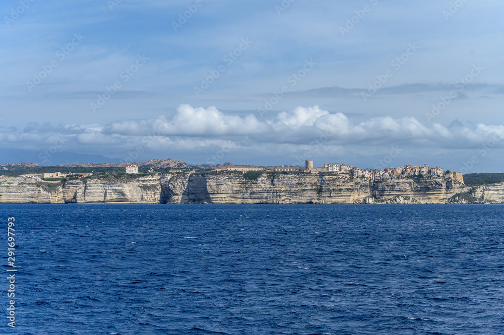 Panoramic view from the sea to the white limestone cliffs and the city of Bonifacio Corsica of the sea and blue sky