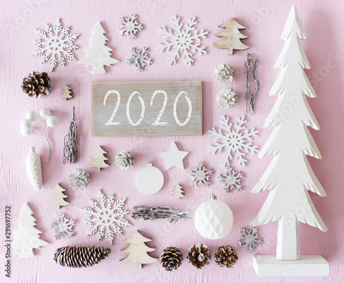 Sign With Text 2020For Happy New Year Greetings. Flat Lay Of Christmas Decoration Like Tree, Ball, Star And Fir Cone. Rose Quarty Wooden Background photo