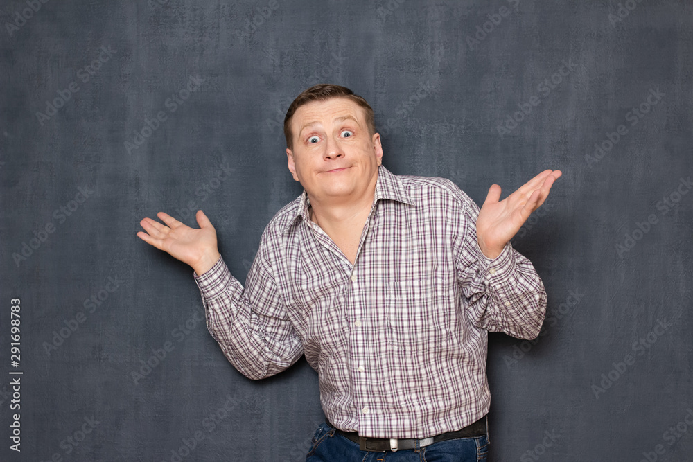 Portrait of man spreading hands and making clueless face Photos | Adobe  Stock