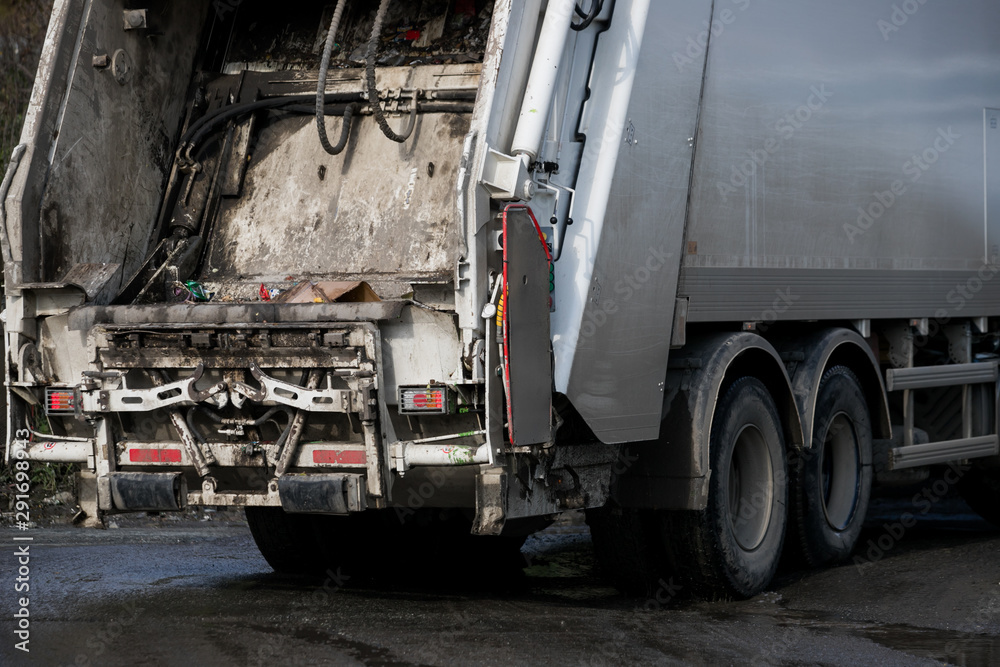 Fototapeta premium Garbage collector loading waste on the street