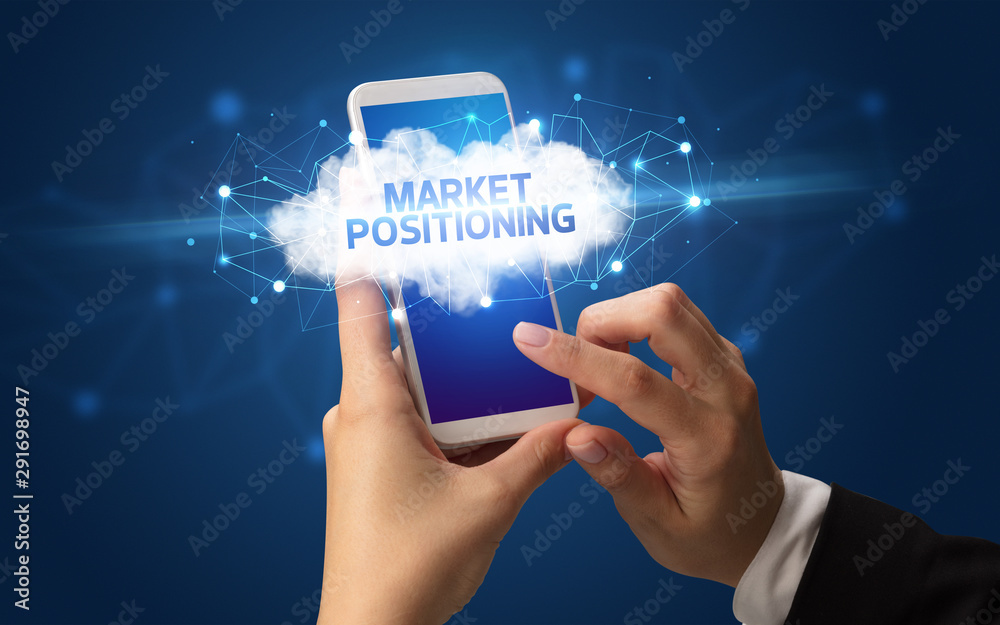 Female hand touching smartphone with MARKET POSITIONING inscription, cloud business concept Female hand touching smartphone with MARKET POSITIONING inscription, cloud business concept