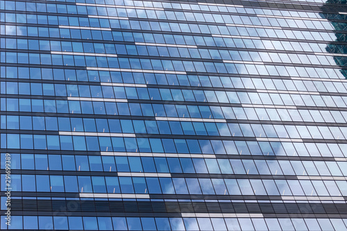 Windows of an office building with reflection of sky and clouds