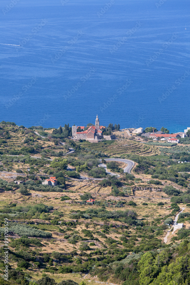 Coastal town lying on the island of Vis on the Adriatic Sea, view on Church of Saint Nicholas, Komiza, Croatia