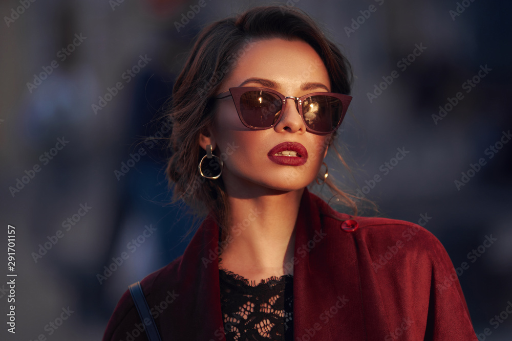 Closeup portrait of young elegant woman wearing sunglasses. Pretty girl with hairstyle and makeup. Outdoor portrait. Sunset light. - obrazy, fototapety, plakaty 