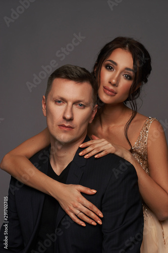 Closeup studio fashion portrait of elegant stylish young adult couple. Caucasian brunette woman with hairstyle.