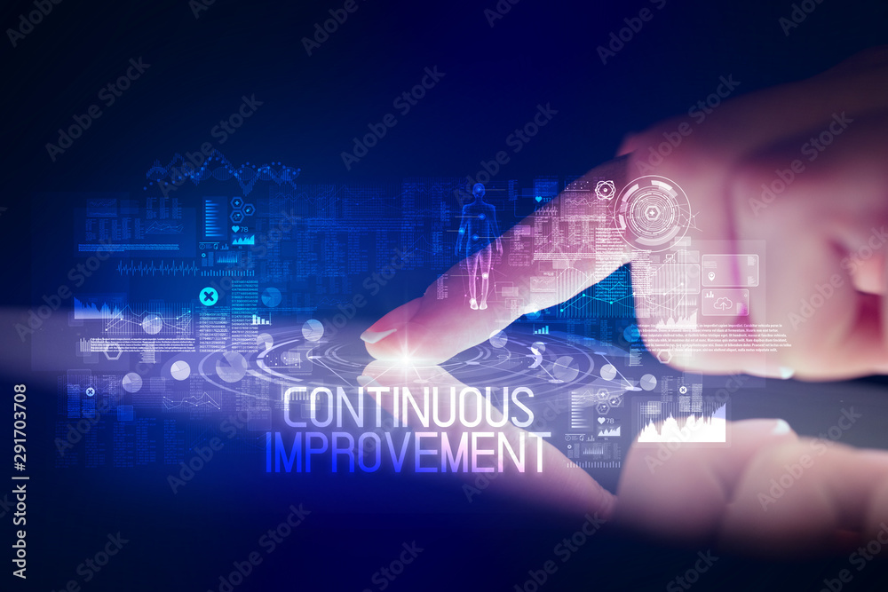 Finger touching tablet with web technology icons and CONTINUOUS IMPROVEMENT inscription Finger touching tablet with web technology icons and CONTINUOUS IMPROVEMENT inscription
