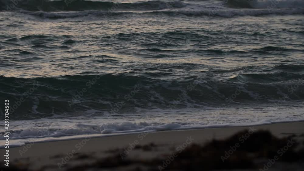Handheld slow motion shot of the sea waves hitting the sandy beach Handheld slow motion shot of the sea waves hitting the sandy beach