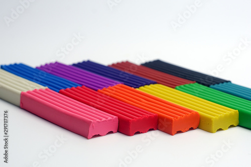 Multicolored set of plasticine sticks on white background.