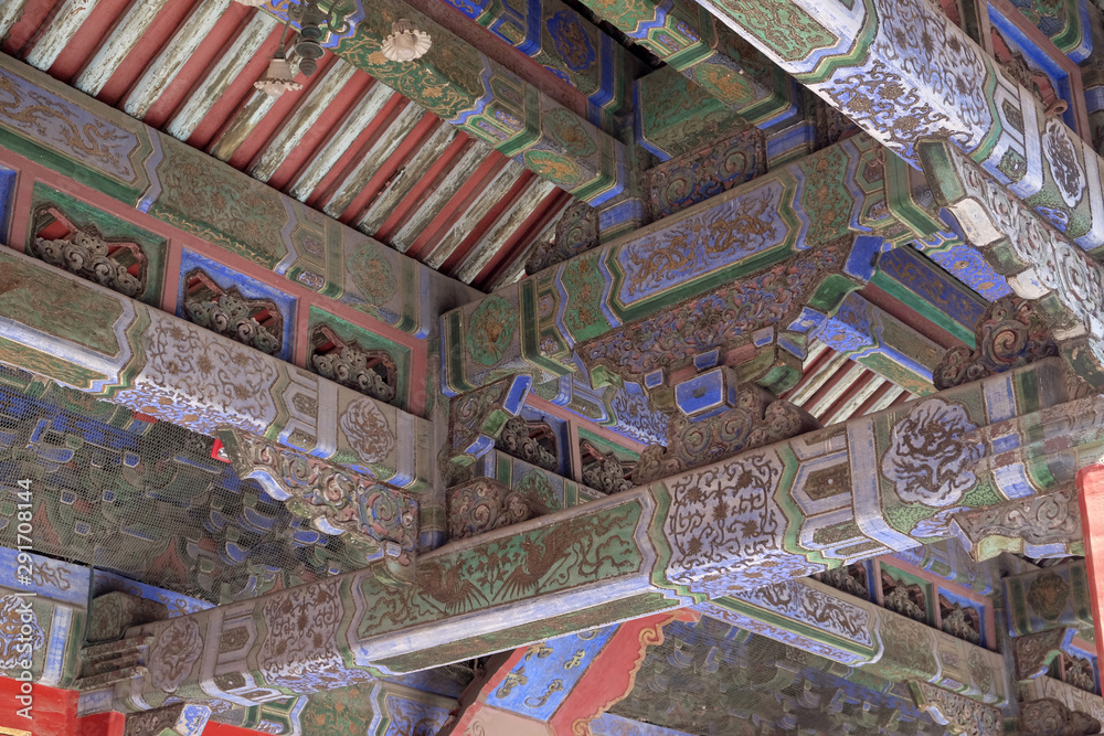 An ornate painted ceiling on a building in the Forbidden City in Beijing, China