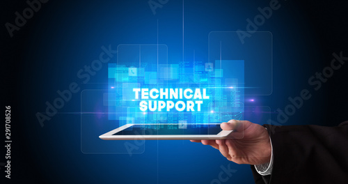 Young business person working on tablet and shows the inscription: TECHNICAL SUPPORT