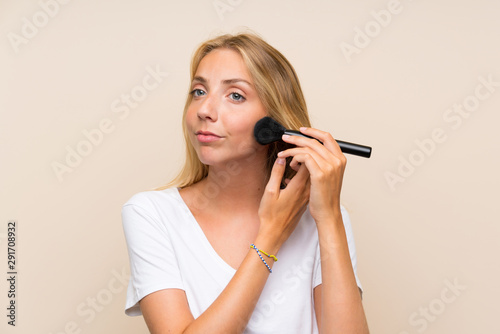 Young blonde woman with makeup brush.