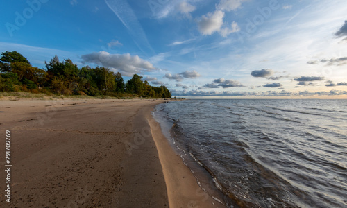 Fototapeta Naklejka Na Ścianę i Meble -  seascape image of the sea with cloudy sky before sunset,  stones and  of light before sunset, beautiful sunny day and quiet sea. baltic sea, Tuja beatch, Latvia