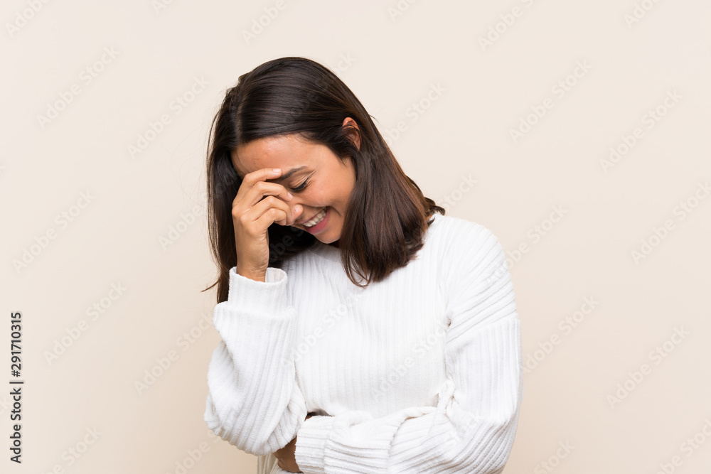 Young brunette woman with white sweater over isolated background laughing Young brunette woman with white sweater over isolated background laughing