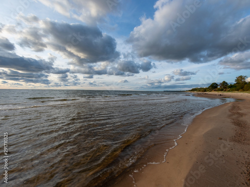 seascape image of the sea with cloudy sky before sunset   stones and  of light before sunset  beautiful sunny day and quiet sea. baltic sea  Tuja beatch  Latvia
