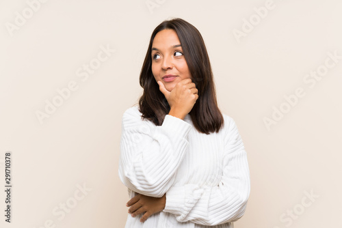 Young brunette woman with white sweater over isolated background thinking an idea