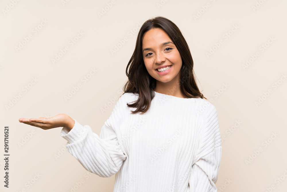 Young brunette woman with white sweater over isolated background holding copyspace imaginary on the palm Young brunette woman with white sweater over isolated background holding copyspace imaginary on the palm