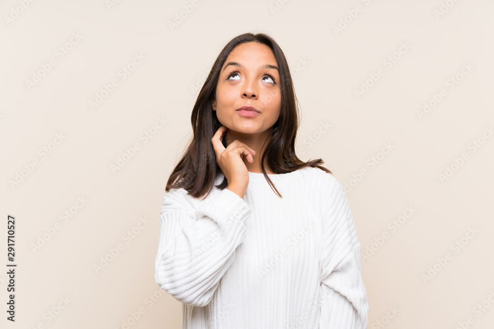 Young brunette woman with white sweater over isolated background thinking an idea Young brunette woman with white sweater over isolated background thinking an idea