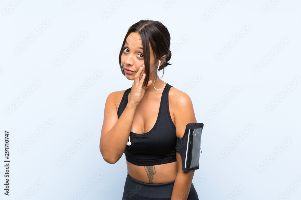 Young sport girl over isolated blue background whispering something Young sport girl over isolated blue background whispering something