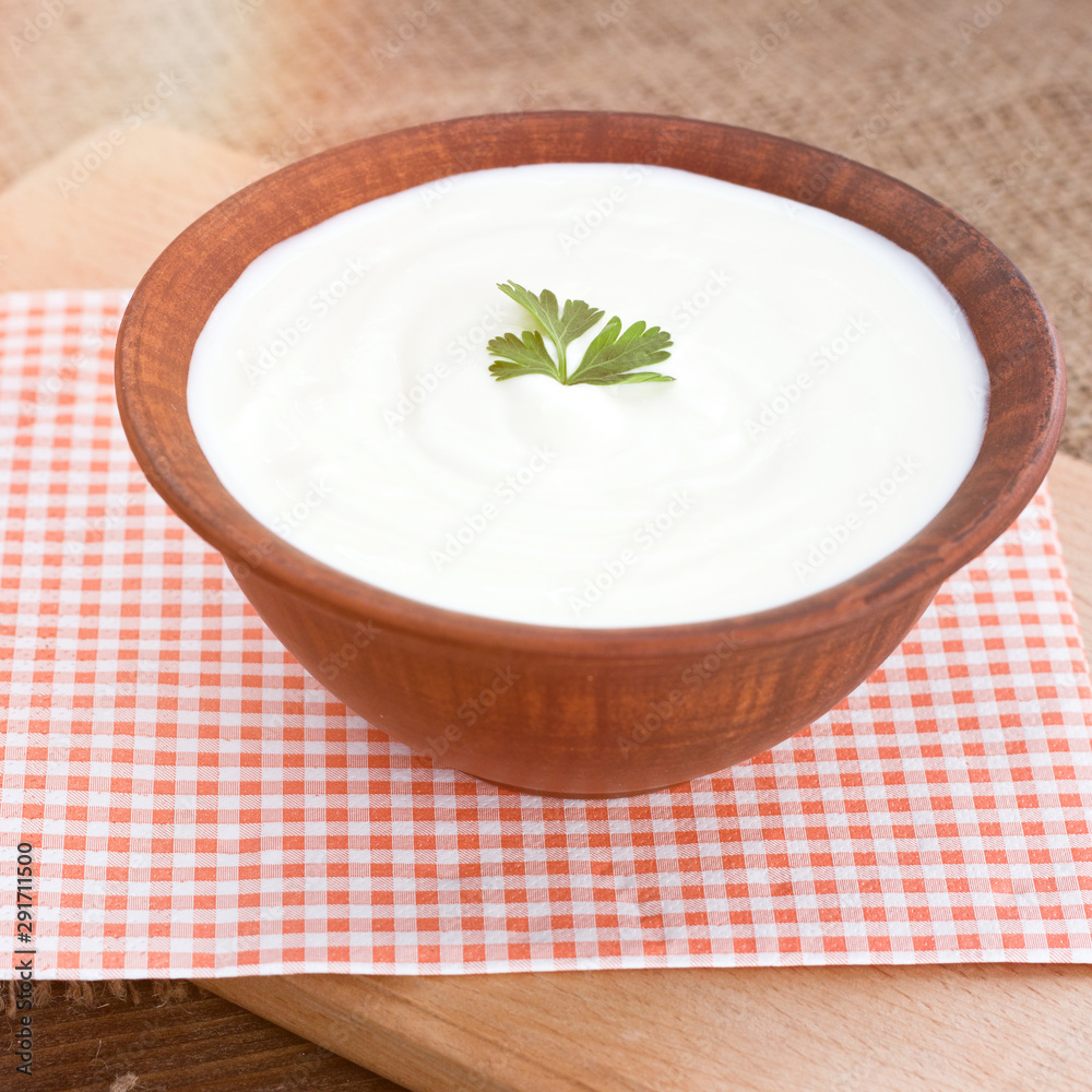Bowl of Greek yogurt.Delicious breakfast. Homemade yogurt on a wooden tray, top view Bowl of Greek yogurt.Delicious breakfast. Homemade yogurt on a wooden tray, top view