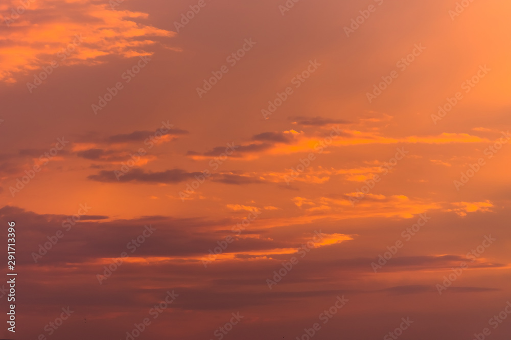 Abstract nature background. Dramatic sunset sky in the clouds saturated with bright colors of orange and yellow. Contrast Low Key