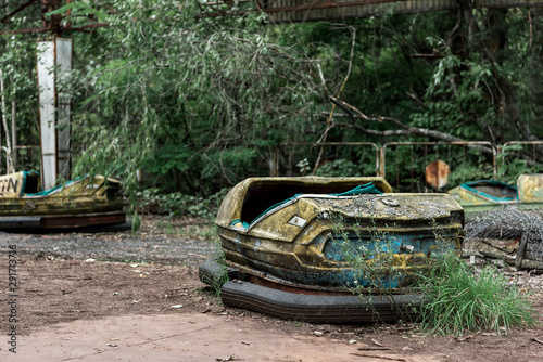 selective focus of abandoned and dirty bumper cars in amusement park photo