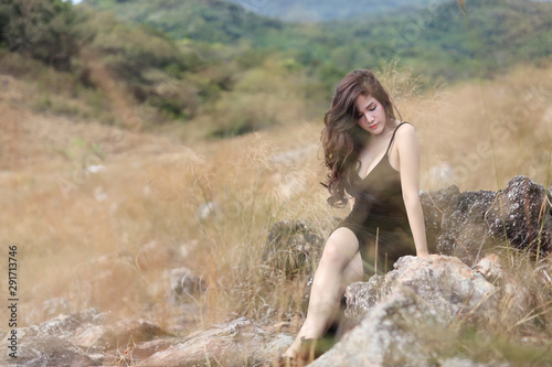 full length young asian woman in black dress sitting in nature outdoors with peaceful on mountain during holiday vacation