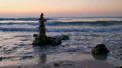 Zen stones in the morning day at the seashore with waves