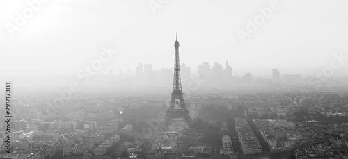Aerial view of Paris with Eiffel tower and major business district of La Defence in background at sunset. Black and white image.