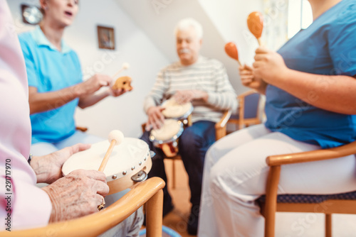 Seniors in nursing home making music with rhythm instruments