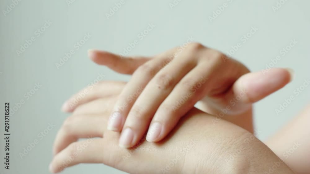 Woman hands applying hand cream.