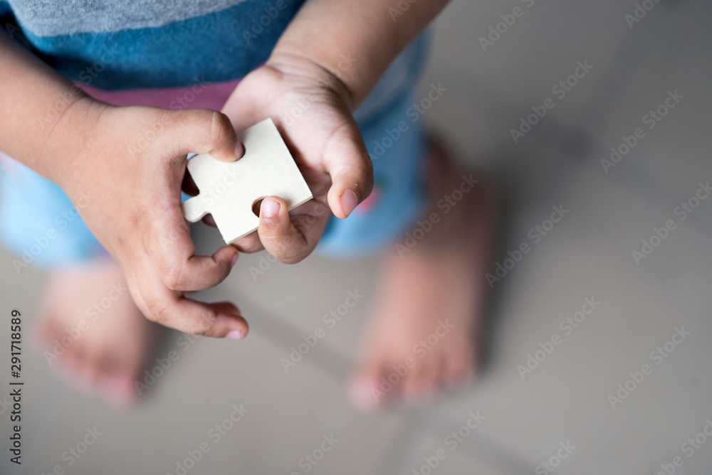 A toddler holding a jigsaw puzzle block