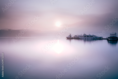 Beautiful tranquil landscape at Sun Moon lake in Nantao, Taiwan. Pier with boats and background of foggy mountains. Concept of peaceful, traanquility of nature. © 9mot