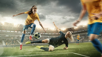 Excitement. Young female soccer or football players in sportwear kicking ball for the goal in action at the stadium. Concept of healthy lifestyle, sport, motion, movement. Collage made of 2 models.