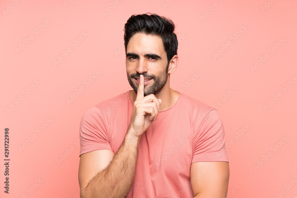 Handsome young man over isolated pink background doing silence gesture Handsome young man over isolated pink background doing silence gesture