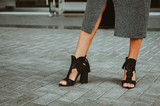 Beautiful female legs in lace high-heeled shoes. Street style, healthy, rested legs, strolling through the urban city.
