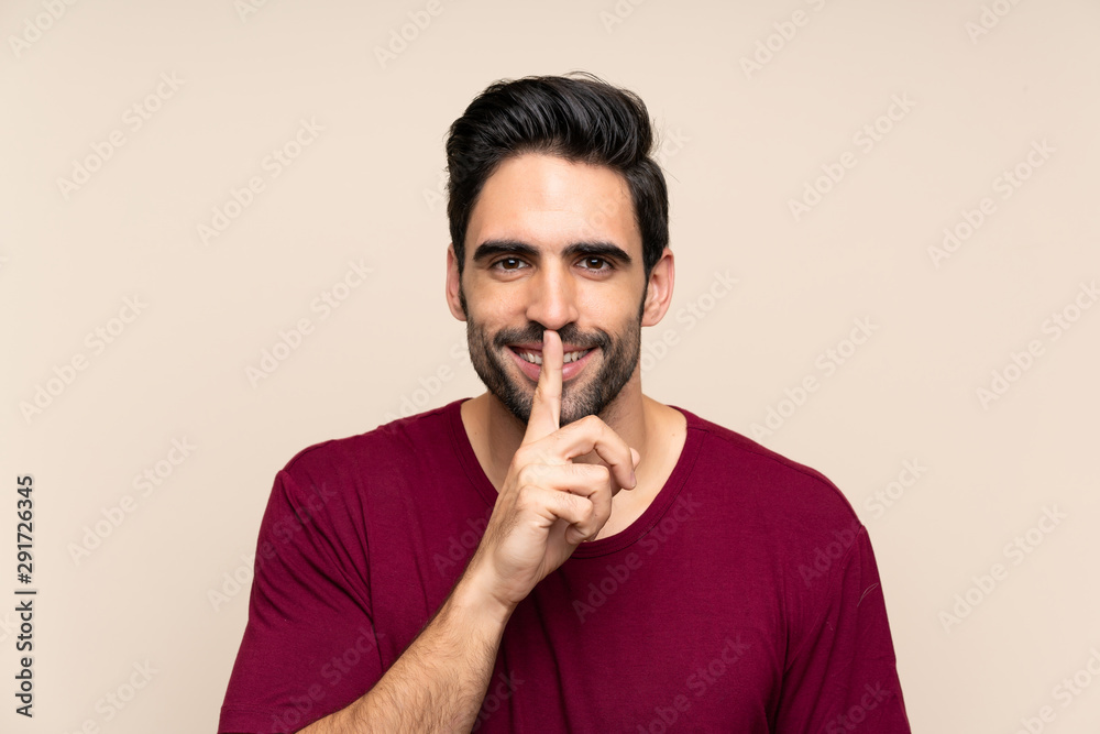 Handsome young man over isolated background doing silence gesture Handsome young man over isolated background doing silence gesture