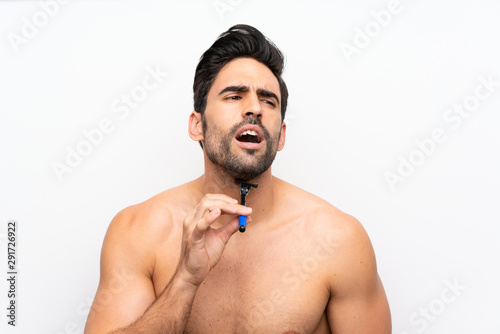 Man shaving his beard over isolated white wall