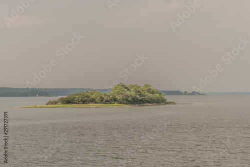 a tiny island with green trees and a jetty in the sea close to Svendborg, Denmark