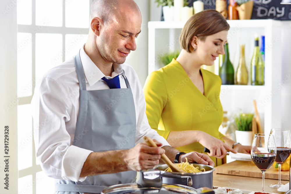 Smiling young couple cooking food in the kitchen Smiling young couple cooking food in the kitchen
