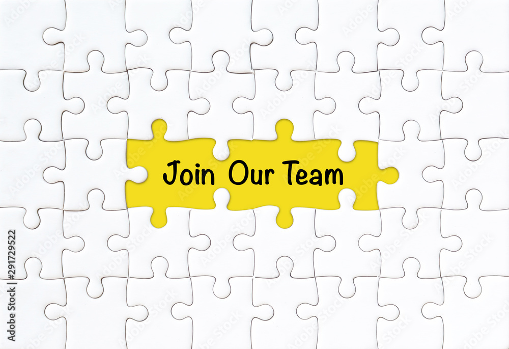 Join our team concept. White jigsaw puzzle with word and yellow background Join our team concept. White jigsaw puzzle with word and yellow background