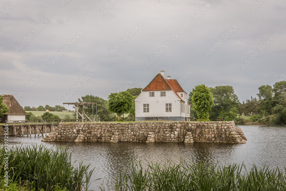 the beautiful manor house Søbygaard behind reed and moat in the island of Ærø in Denmark