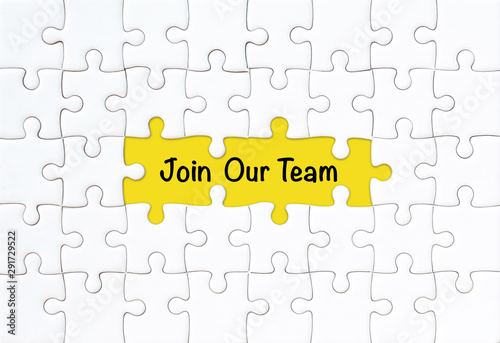 Join our team concept. White jigsaw puzzle with word and yellow background