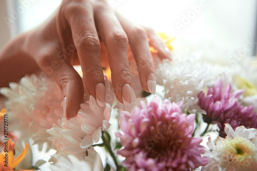 Beautiful women's hands against the background of flowers. French