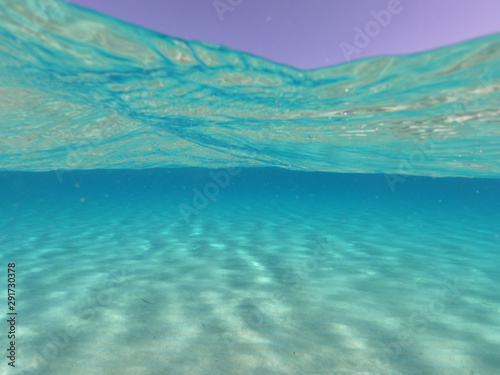 Sea level and underwater photo of tropical exotic sandy beach with turquoise clear sea in popular Caribbean destination