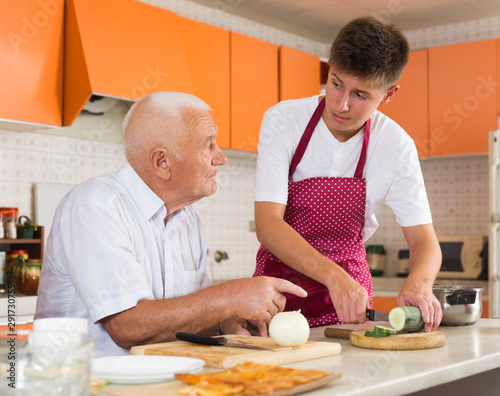 Man and his grandson making dinner