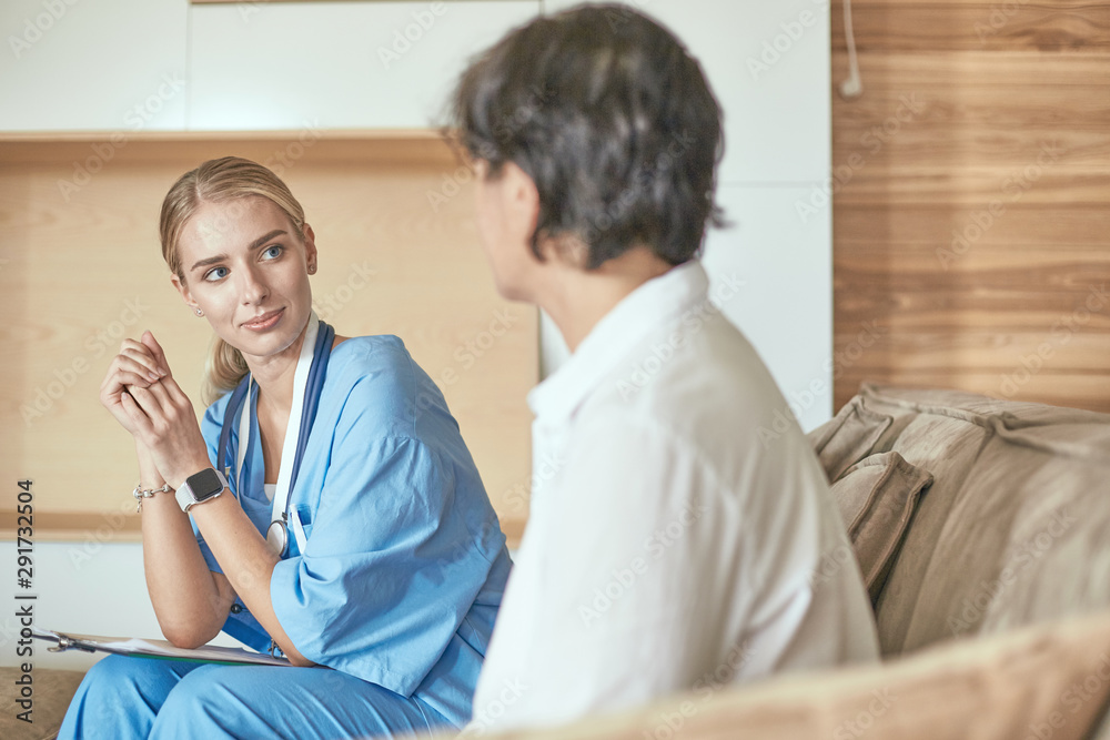 Obraz premium Friendly smiling doctor and patient sitting on the couch. Very